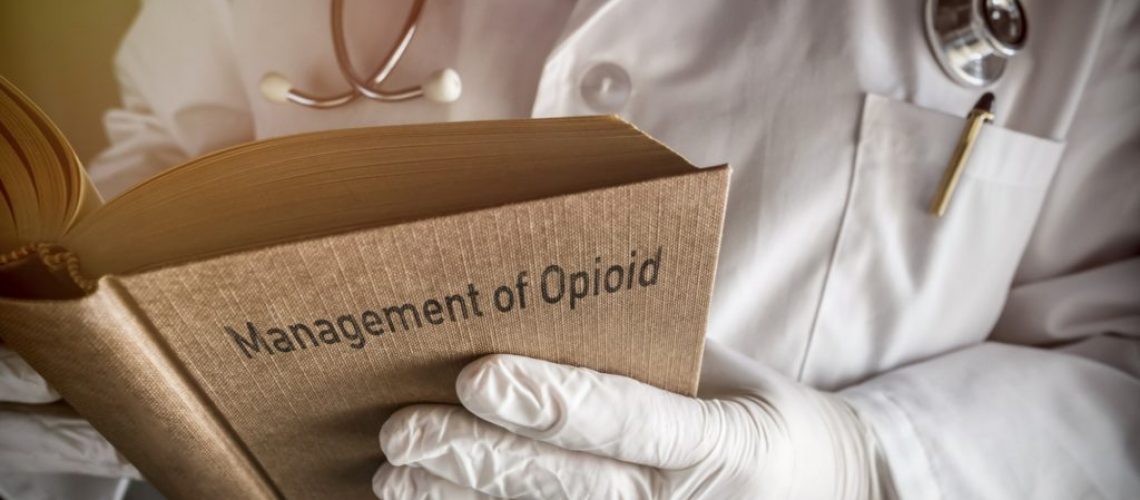 doctor-holds-book-on-management-of-opioid-conceptual-image-1024x682